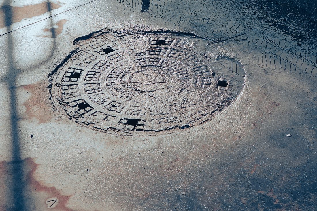 Commercial cesspool access cover in a Suffolk County, NY parking lot serviced by Pay Much-Le$$ Cesspool